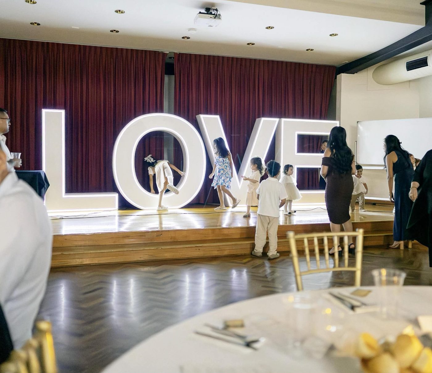 Children climbing through the giant lit LOVE letters on the dance floor